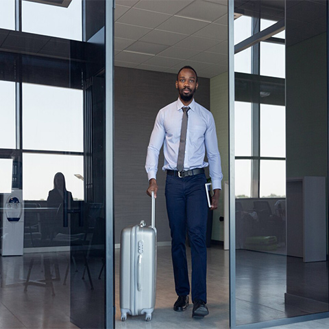 A business traveller leaving the office with his case